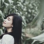 girl walking through field of corn