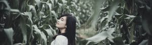 girl walking through field of corn